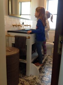 This is an image is two kids using our Step-Up kids vanity with built in fold down stool.