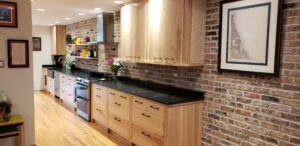 This image shows the sink/stove side wall with Birch cabinets. The upper cabinets are solid wood slab doors. This image shows the two floating wood Birch shelves. 