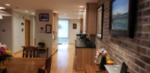 This image shows the kitchen, and how it fits into the opened up floor plan opening up into the living space, and dining room. The brick wall on the right side of the image on the stove wall was re bricked to match the existing brick wall that needed to be patched in spots. 