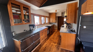 Another angle of the sink side base cabinets. The under counter drawer Fridge and Freezers on the far Left near outdoor shelter. To the right is a base cabinet with a bank of drawers on the left, and to the right of the bank of drawers. The smaller drawer on the Left matches the width of the Recycling and Garbage pull-out drawer with a shallow drawer beneath it. These two are set back 2" back from the upper drawer at the top. Around the sink there is a removable front to access the radiator beneath the sink. to the right of the sink there is a Double Dishdrawer. Next to the Dishdrawers and far right are a bank of 4 drawers with the top drawer 2" out from the lower three drawers. Glen Ellyn Hilltop Gallery