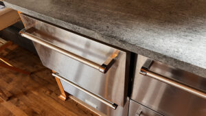 This image shows a closeup of the Fridge and Freezer drawers at the east end of the sink wall run near the outdoor shelter. 