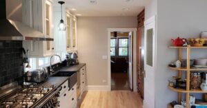 This image shows the kitchen facing the towards the front of the house. The origal kitchen ended at the wall that the shelving unit is up against.